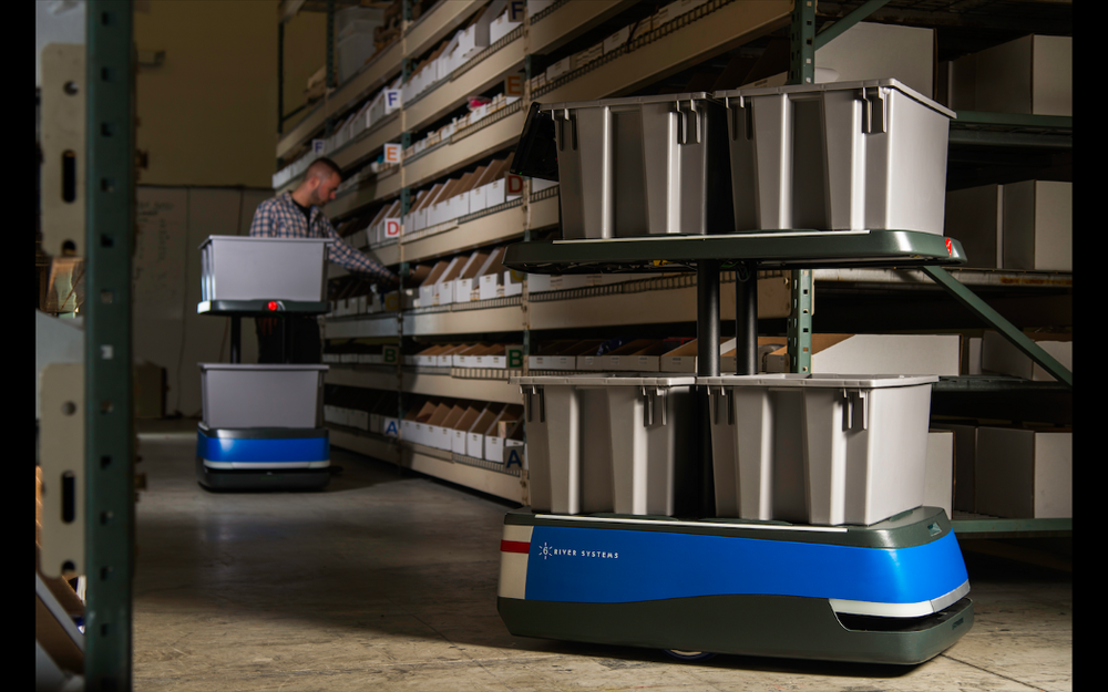 6 River Systems robots lead workers to items they need to get from a warehouse shelf.